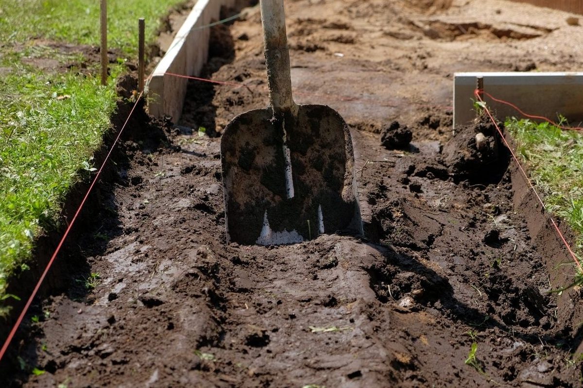 Schep in losse grond tussen gespannen draden